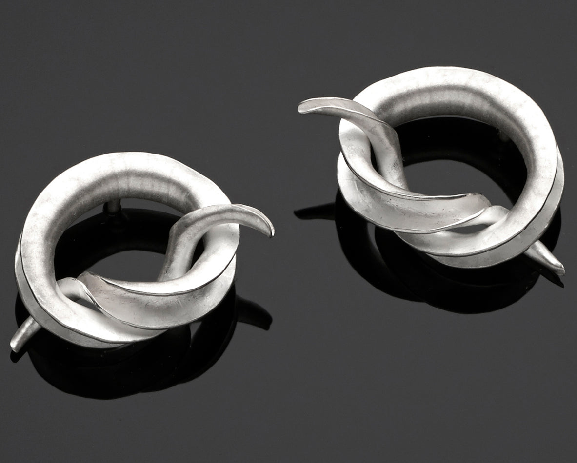 Celebrate tying the knot with a pair of mirror-image stud earrings, each in the form of an open-sided tube tied into a simple knot.