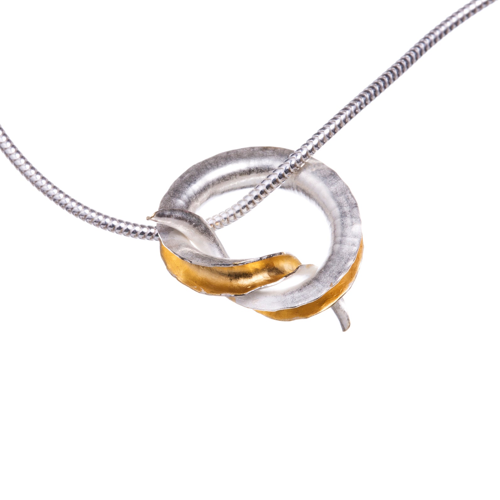 A silver pendant in the shape of a knot, in the form of a tube open down one side and gold plated on the inside, hanging from a silver snake chain.