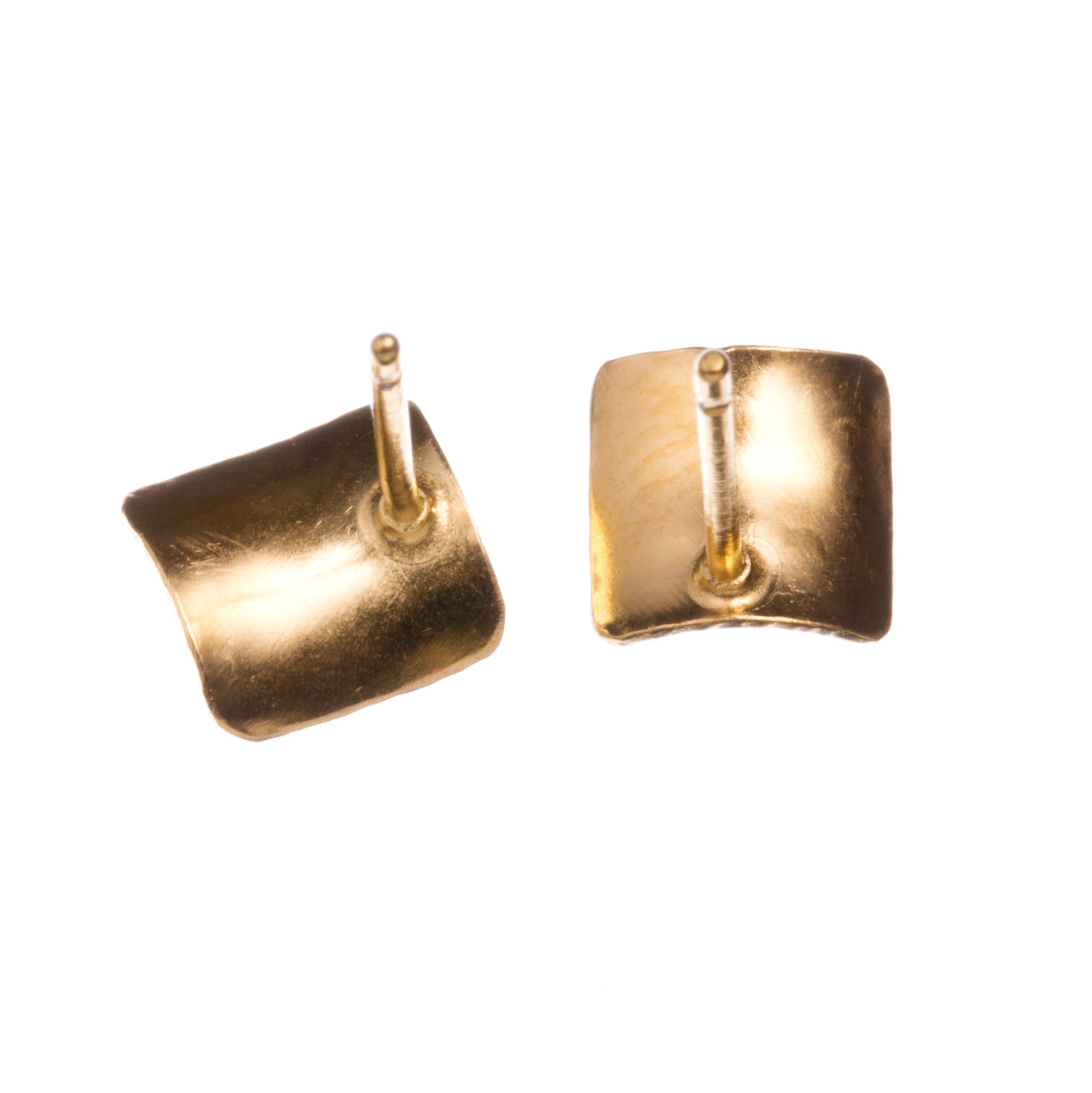 A pair of square silver earrings, studs, gold plated, with a subtle curve, a hammered texture and burnished edges. Showing the attachment at the back of the pins.