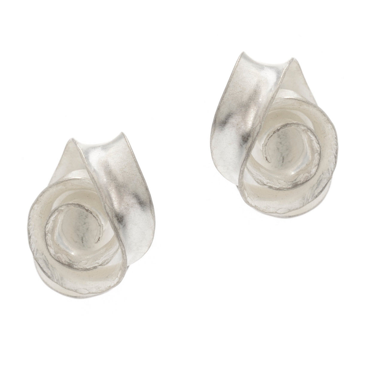 A peir of delicate swirl earrings made from recycled sterling silver. Each stud is made from a single piece of silver, with a spiralloing ribbon of metal twisting so that it lies flat against a curved backing.
