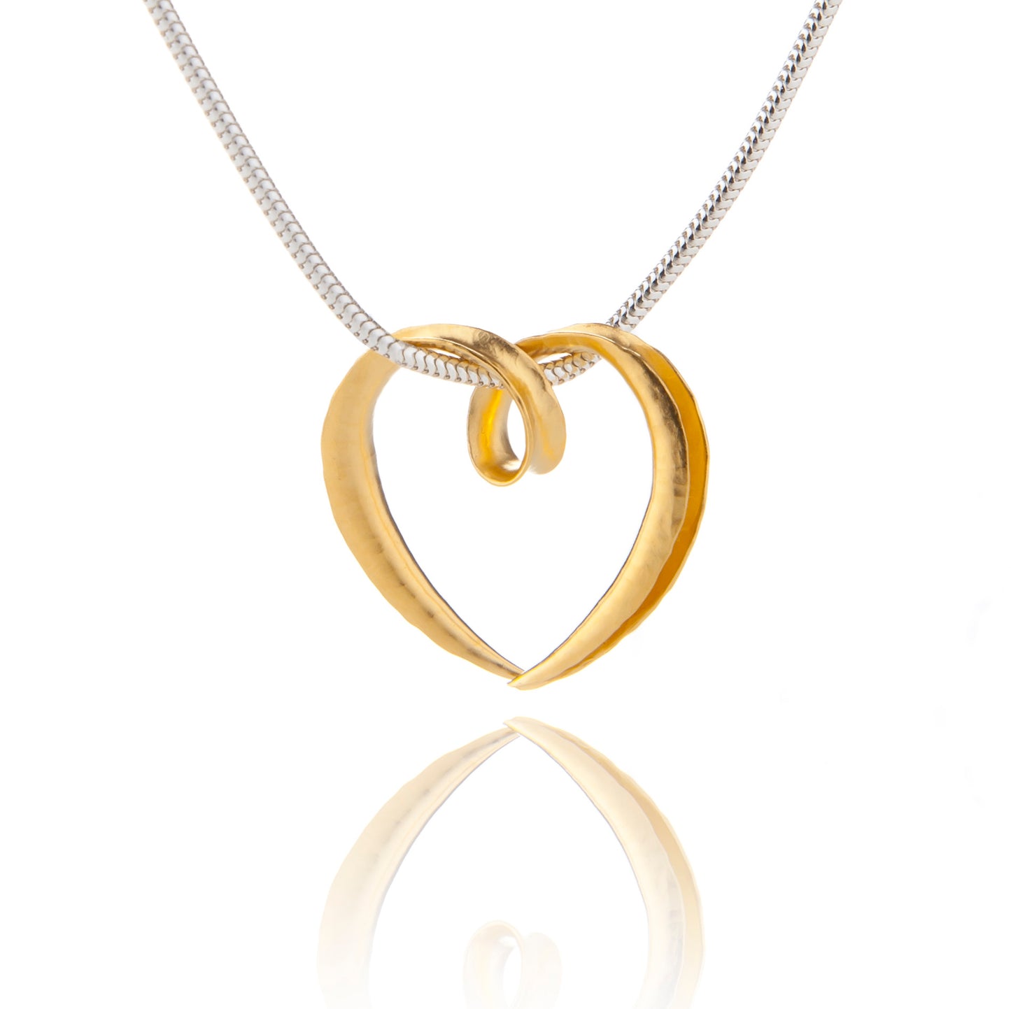 A small silver heart pendant made from a single piece of metal, formed into a sort of tube with the outer side open and gold plated all over. It is formed into a loop at the top which the chain passes through.