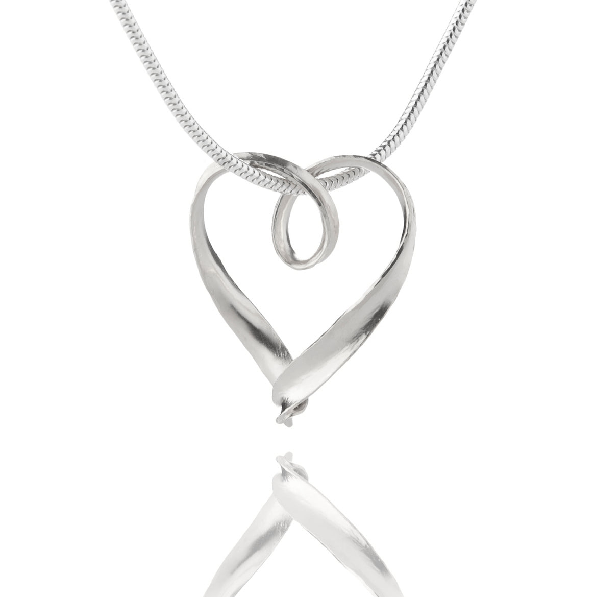 A simple silver heart pendant formed from a continuous strip of recycled silver, hanging from a silver snake chain which passes through a loop in the heart.